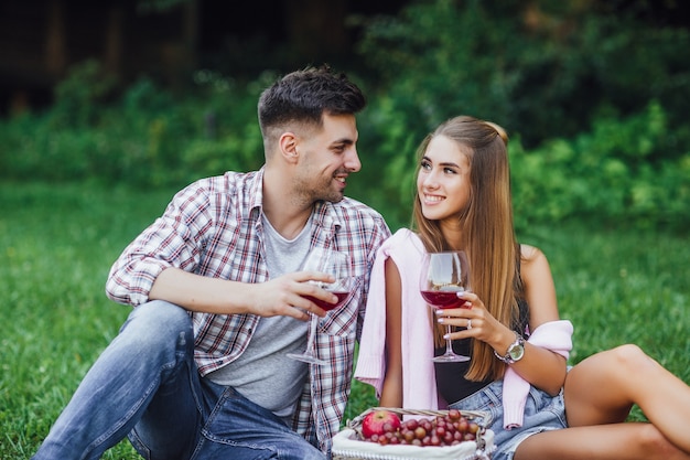 Free photo man and woman in park with red wine