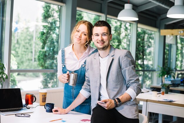 Man and woman posing in office