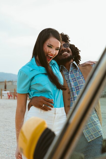 Man and woman posing in retro style with car