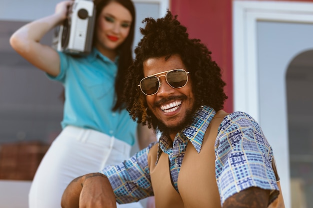 Man and woman posing together in retro style with radio player