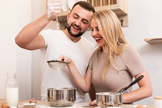 Man and woman pouring flour