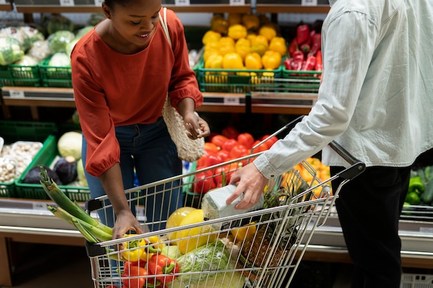 Uomo e donna che acquistano al negozio di alimentari