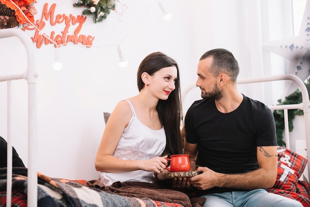 Man and woman sitting on bed 