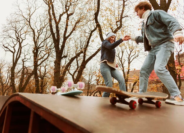 Free photo man and woman skateboarding outdoors