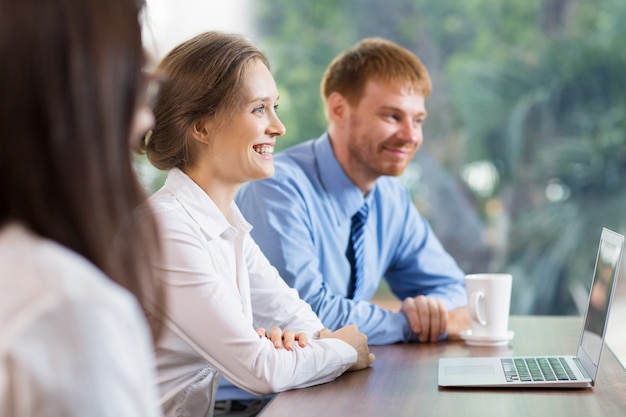 Man and woman smiling at a laptop