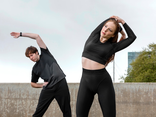 Мужчина и женщина в спортивной одежде, упражнения на открытом воздухе
