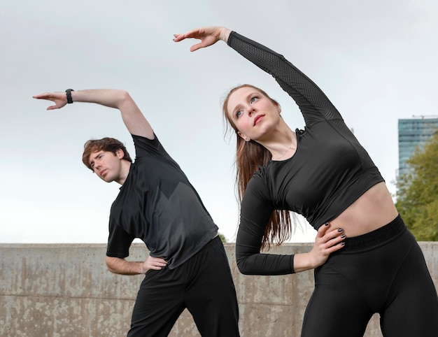 Мужчина и женщина в спортивной одежде, упражнения на открытом воздухе