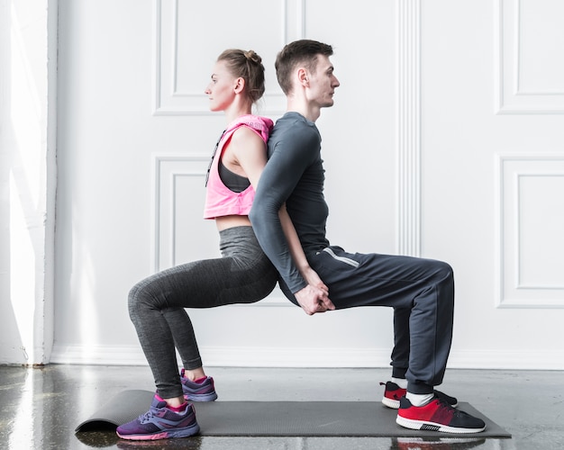 Man and woman squatting back to back