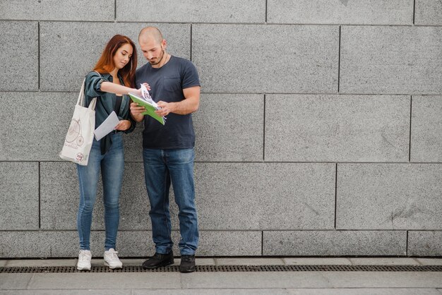 Man and woman standing against gray wall