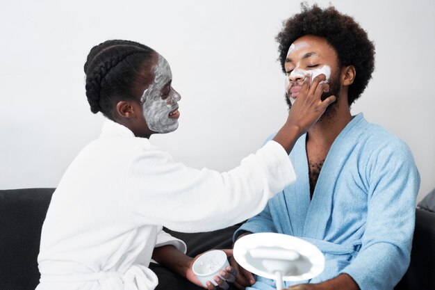 Man and woman taking care of their face at home