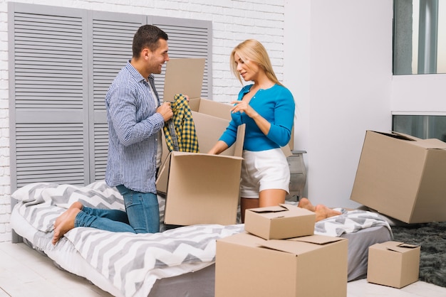 Free photo man and woman unpacking boxes