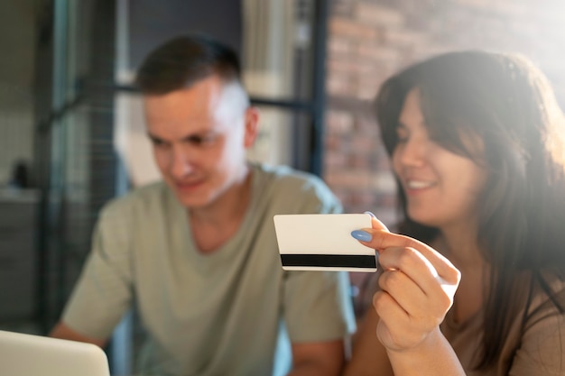 신용 카드로 온라인 쇼핑을 위해 노트북을 사용하는 남녀