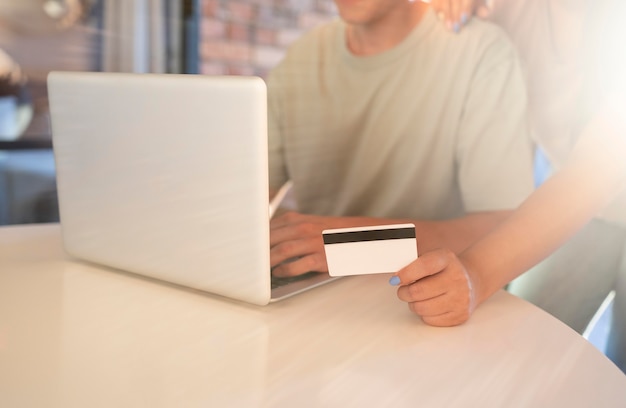 Man and woman using laptop for online shopping with credit card