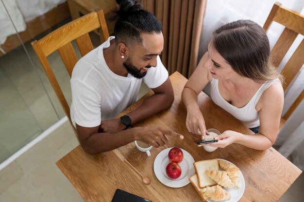 キッチンで携帯電話を使用している男性と女性