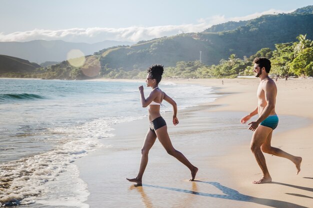 ビーチで水の方に歩いている男と女