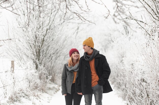 Man and woman walking in the winter forest