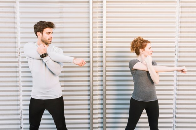 Man and woman warming up near wall