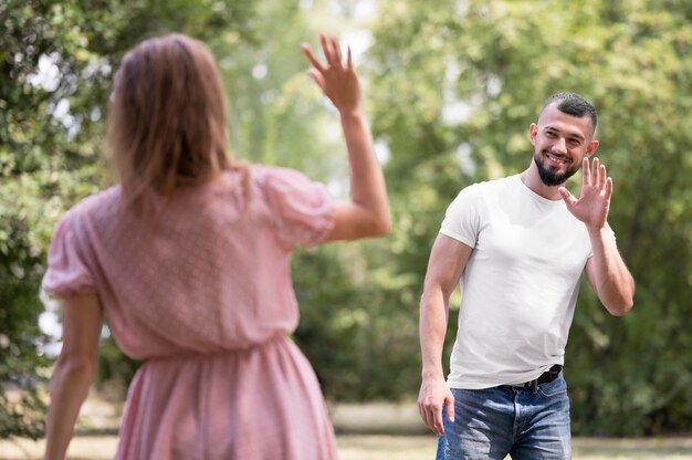 Man and woman waving at each other