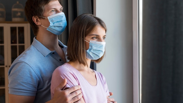 Man and woman wearing face mask at home