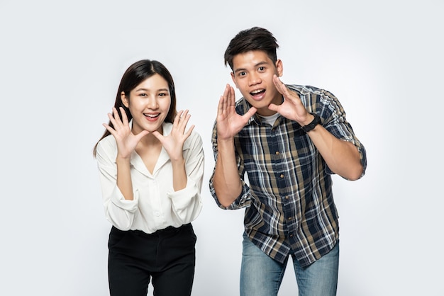 Free photo man and woman wearing shirts and making hands shouting congratulations