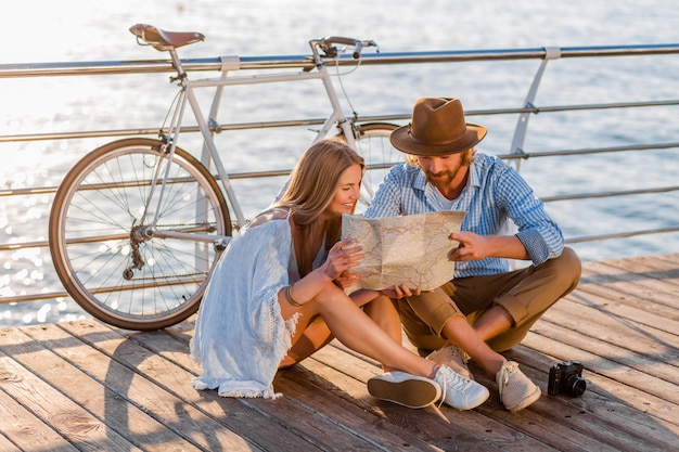 man and woman with blond hair boho hipster style fashion having fun together, looking in map sightseeing