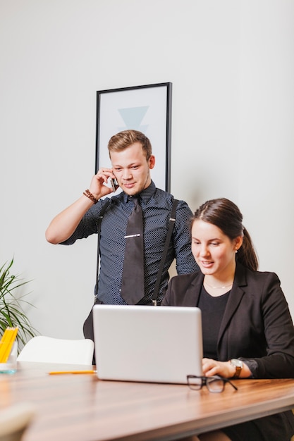 Man and woman with gadgets in office