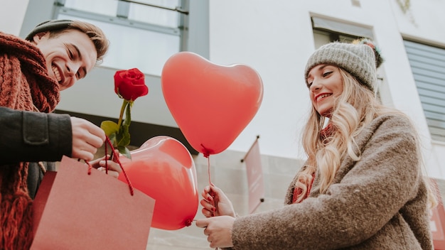 Man and woman with gifts and heart balloons