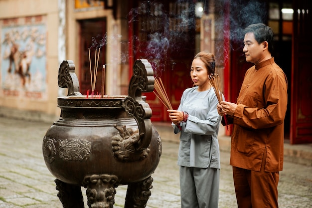 Man and woman with incense at the temple