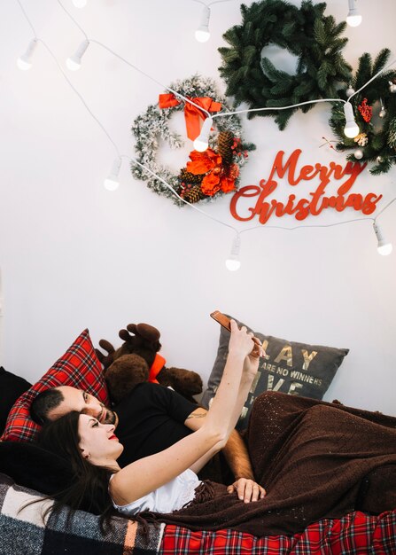 Man and woman with mobile phone on bed