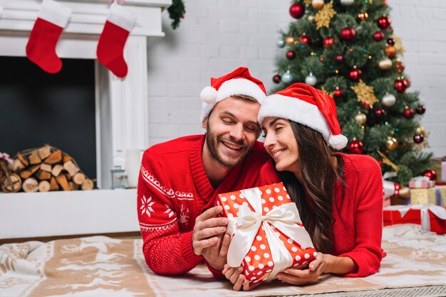 Man and woman with present box on floor 