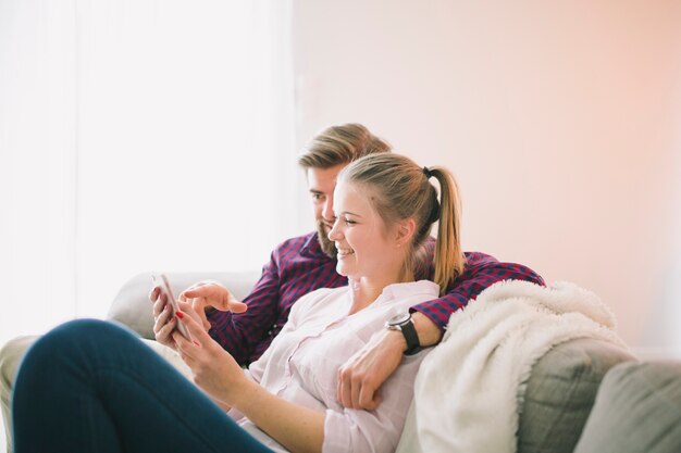 Man and woman with smartphone at home