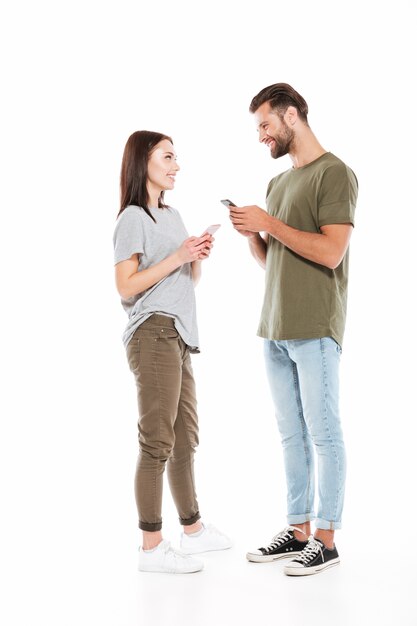 Man and woman with smartphones looking at each others