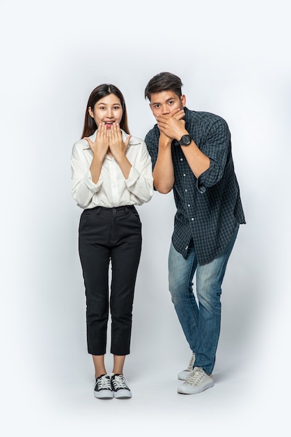 Free photo the man and woman wore shirts and covered their mouths with their hands in shock