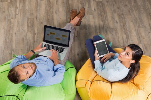 Man and Woman Working on Bright Beanbag Chairs