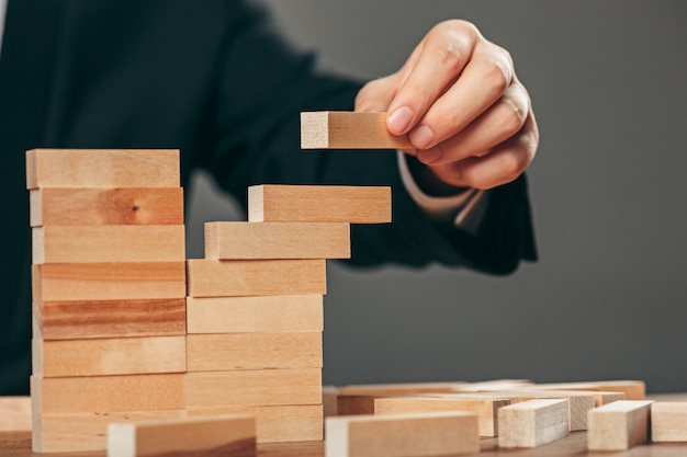 Man and wooden cubes on table. Management concept