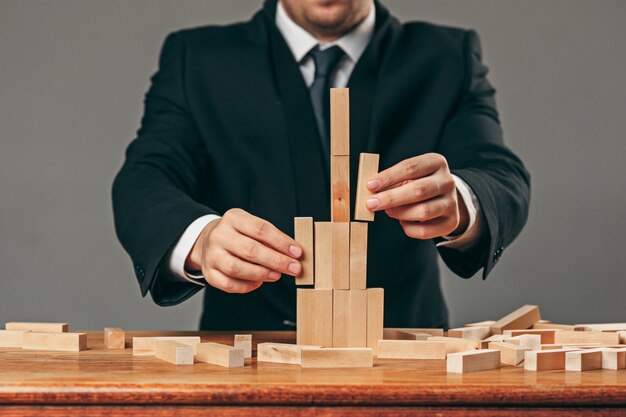 Man and wooden cubes on table. Management concept