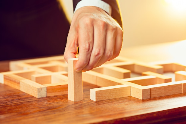 Uomo e cubi di legno sul tavolo. concetto di gestione