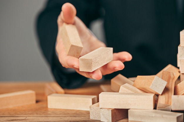 Man and wooden cubes on table. Management concept