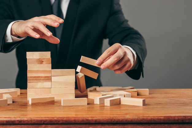 Man and wooden cubes on table. Management concept