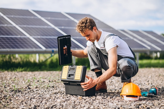 Man worker in the firld by the solar panels