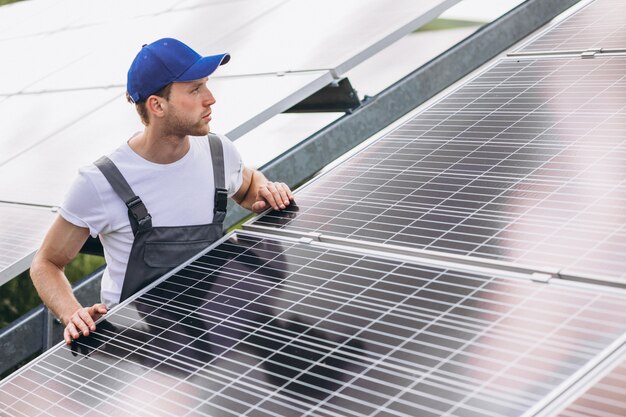 Человек рабочий в первых рядах от солнечных батарей