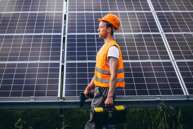 Man worker in the firld by the solar panels