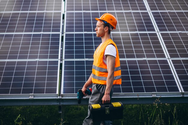 Man worker in the firld by the solar panels