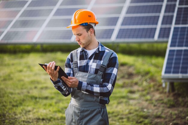 Man worker in the firld by the solar panels