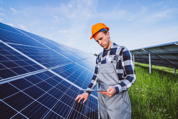 Человек рабочий в первых рядах от солнечных батарей