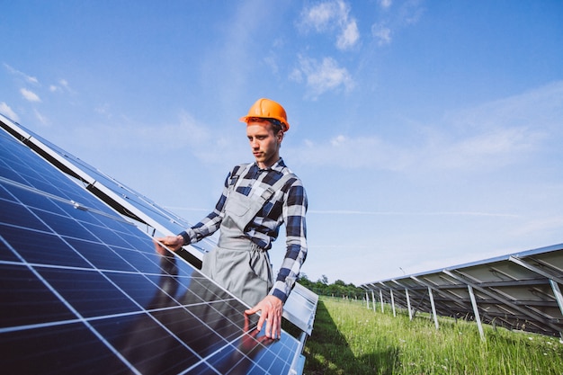 Man worker in the firld by the solar panels