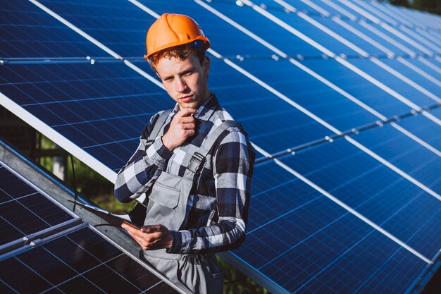 Man worker in the firld by the solar panels