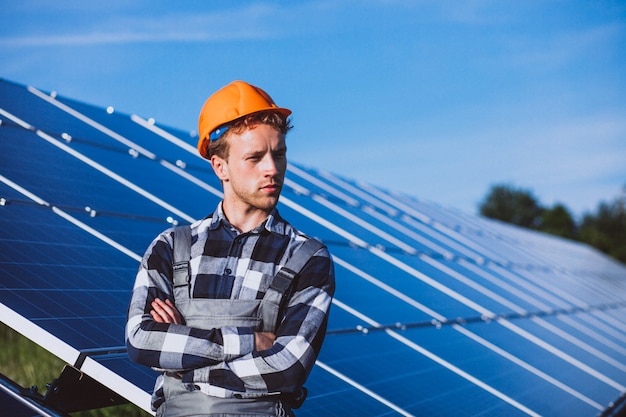 Man worker in the firld by the solar panels