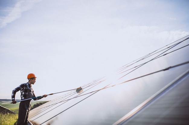 Man worker in the firld by the solar panels