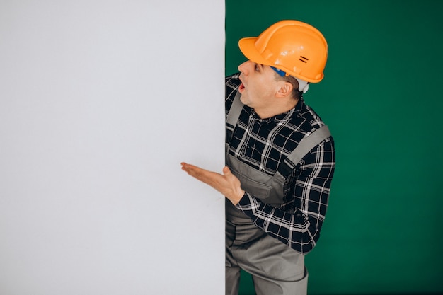 Бесплатное фото Рабочий человек в каске на зеленой стене